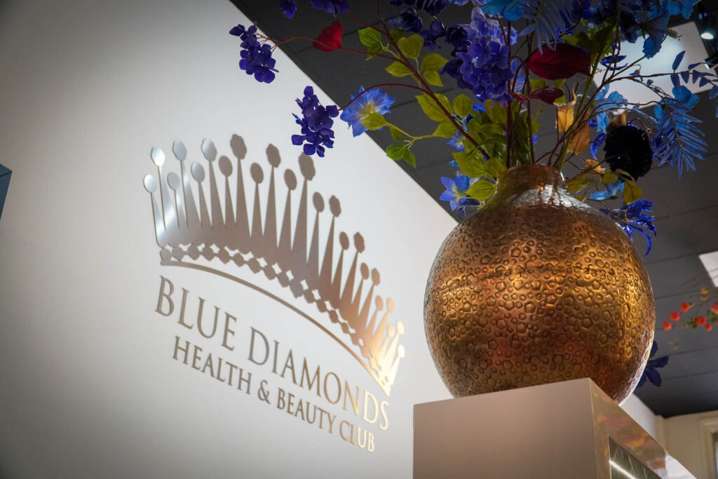 Blue Diamonds logo met bloemen en gouden vaas in receptie
